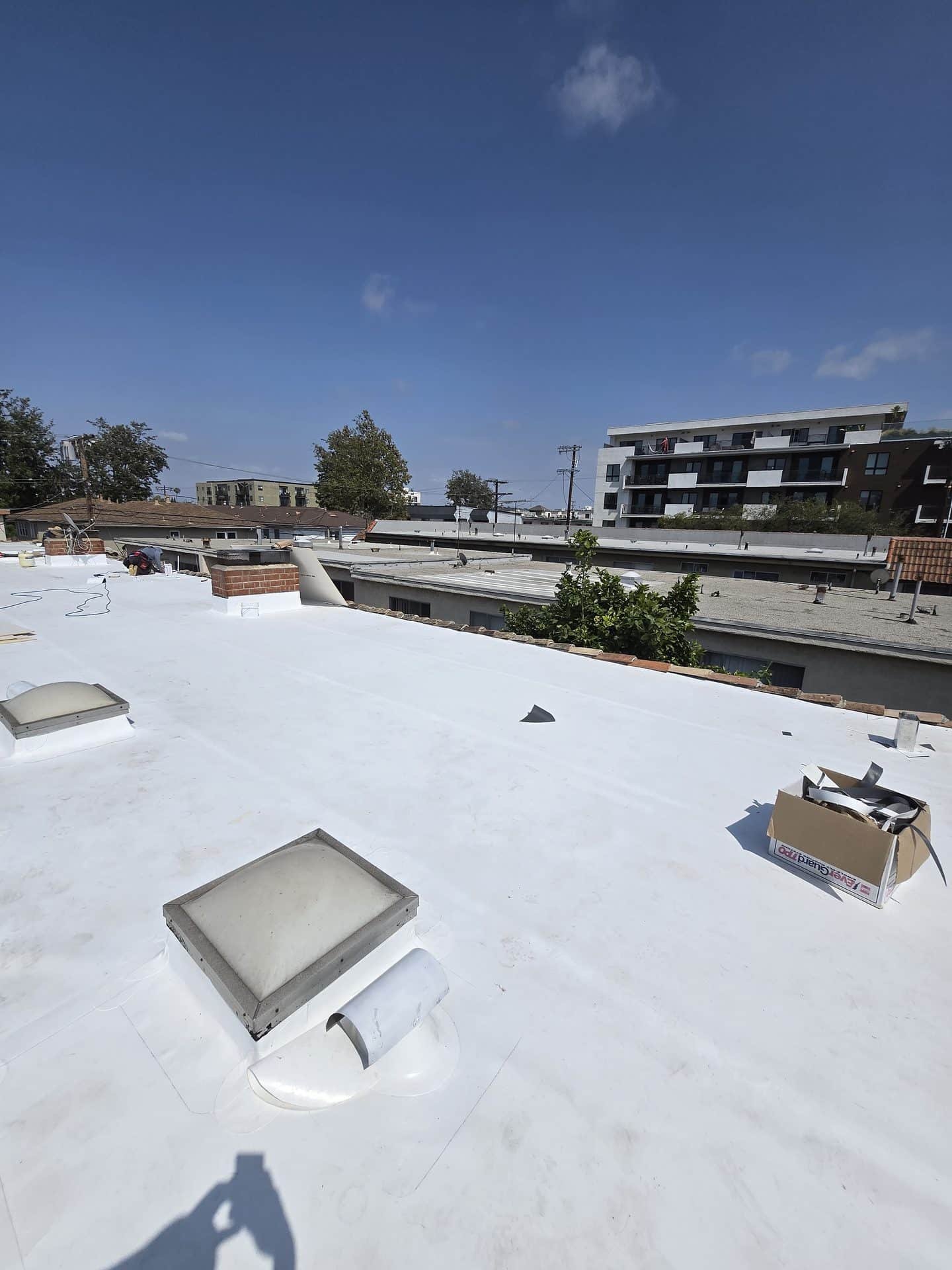 TPO membrane being heat-welded around a skylight during a flat roof installation in Los Angeles